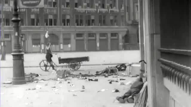 Padvinder met witte vlag loopt met platte kar richting Nieuwe Kerk